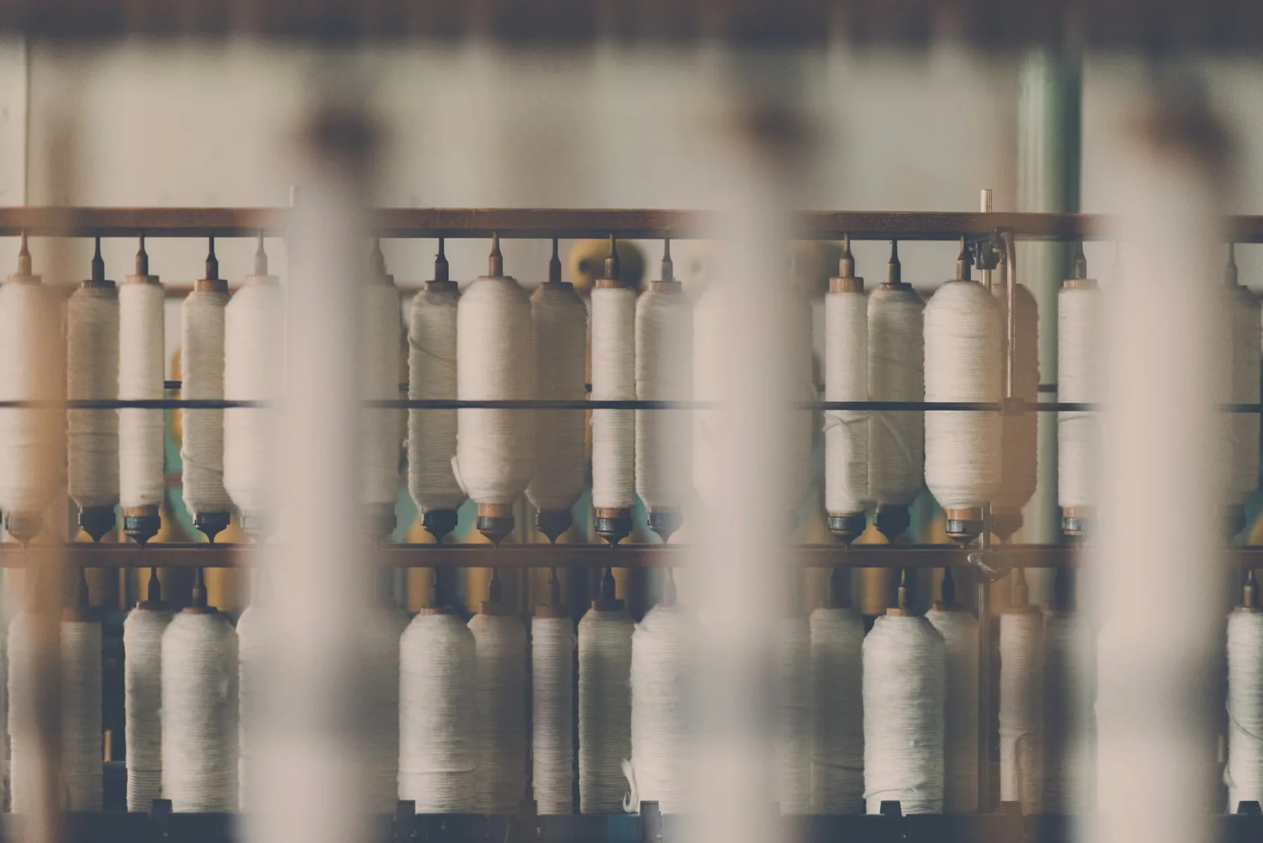 Rangs de bobines de fil blanc sur une machine textile industrielle